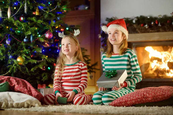 Happy Little Sestry Nosí Vánoční Pyžamo Otevírání Dárkové Krabičky Krbu — Stock fotografie