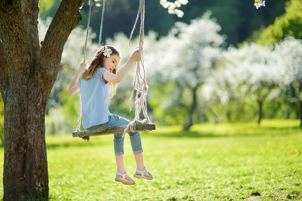 Χαριτωμένο Μικρό Κορίτσι Διασκεδάζοντας Swing Στην Άνθηση Παλιά Κήπος Δέντρα — Φωτογραφία Αρχείου