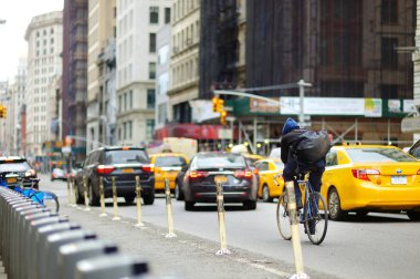 New York - 16 Mart 2015: Bisikletçi ve meşgul şehir Manhattan sokaklarında acele sarı taksi taksi.