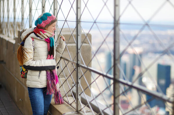 Young woman tourist at observation deck of Empire State Building in New York City