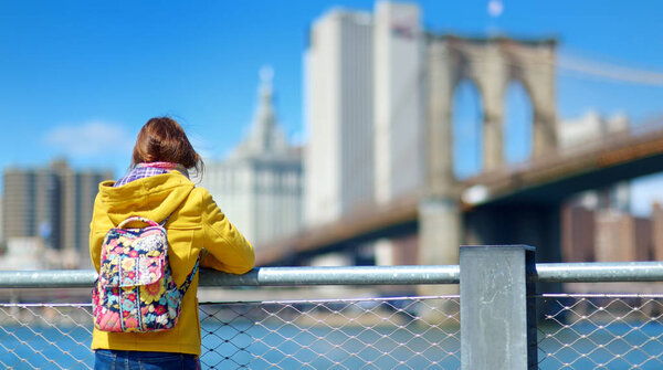 Rear view of woman tourist sightseeing by Brooklyn Bridge, New York City