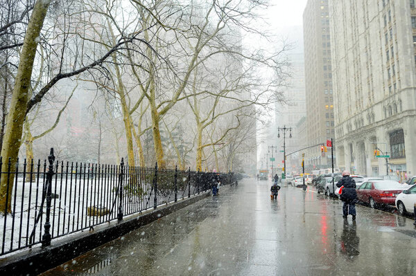 NEW YORK - MARCH 19, 2015: Cars, taxi cabs and people rushing on busy streets of downtown Manhattan during massive snowfall