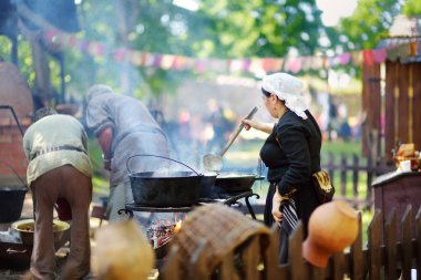 Trakai, Litvanya - 16 Haziran 2018: yıllık Ortaçağ Festivali sırasında açık ateşte gıda hazırlama tarihi canlandırma eylemciler