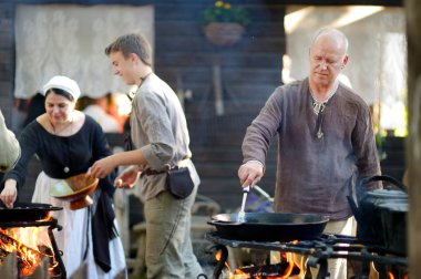 Trakai, Litvanya - 16 Haziran 2018: yıllık Ortaçağ Festivali sırasında açık ateşte gıda hazırlama tarihi canlandırma eylemciler