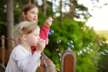 Sevimli küçük kız güzel yaz günü sabun köpüğü üfleme