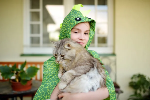 Cute girl wearing fancy costume holding her cat on sunny summer day