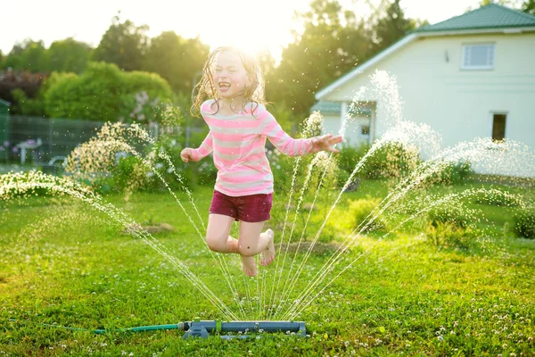 Gadis Kecil Yang Manis Bermain Dengan Sprinkler Halaman Belakang Pada — Stok Foto