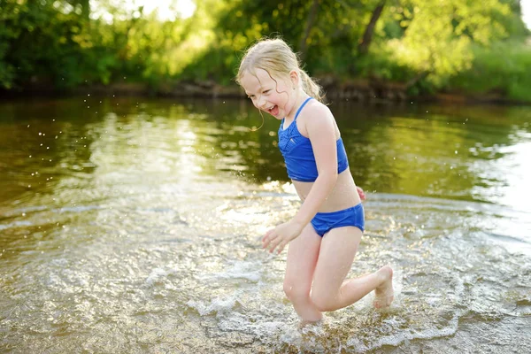 炎热的夏天 可爱的年轻女孩穿着泳衣在河边玩耍 — 图库照片