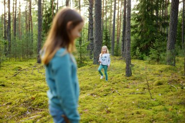 Orman sırasında eğlenmek iki sevimli genç kız kardeş güzel yaz gününde yürüyüş