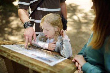 İki sevimli genç kız ormandaki göl güzel yaz gününde babalarıyla hiking
