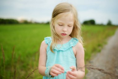 Sevimli küçük kız güneşli yaz akşamı dışarıda eğleniyor