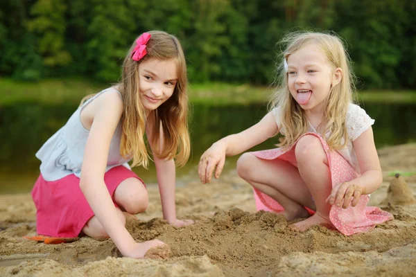 人の若い姉妹は暖かい夏の日に湖の砂浜ビーチで楽しんで — ストック写真