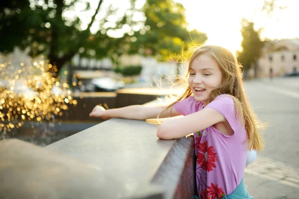 かわいい女の子に暑く晴れた夏の日に市の泉で遊んで — ストック写真