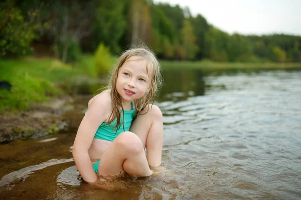 暑い夏の日に川で遊ぶ水着を着たかわいい少女 — ストック写真