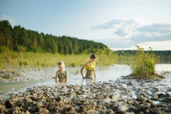 两个年轻姐妹在立陶宛维尔纽斯附近的 Gela 湖上洗澡治疗泥 — 图库照片