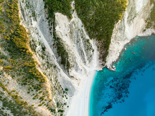 Aerial view of Myrtos beach, the most famous and beautiful beach of Kefalonia, a large coast with turqoise water and white coarse sand, surrounded by steep cliffs. — Stock Photo, Image