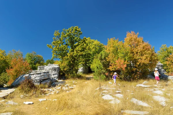 Due giovani ragazze che esplorano la foresta di pietra, formazione rocciosa naturale, creata da più strati di pietra, situata vicino al villaggio di Monodendri nella regione di Zagori, Grecia del Nord . — Foto Stock