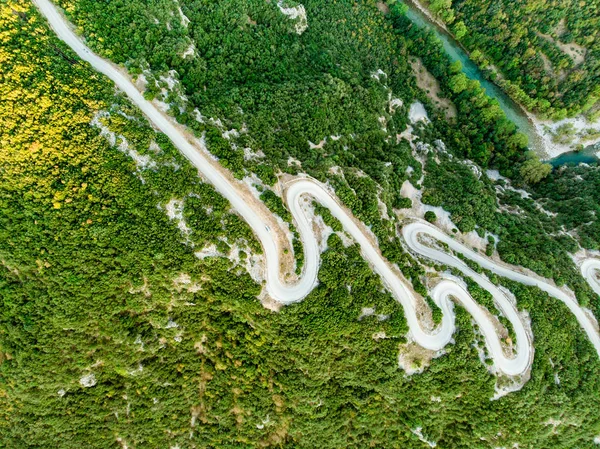 Вид сверху на узкую змеиную дорогу, ведущую в ущелье Викос в Северной Греции. Дорога, заполненная туристами и туристами, намотала гору в Загорском районе Греции . — стоковое фото