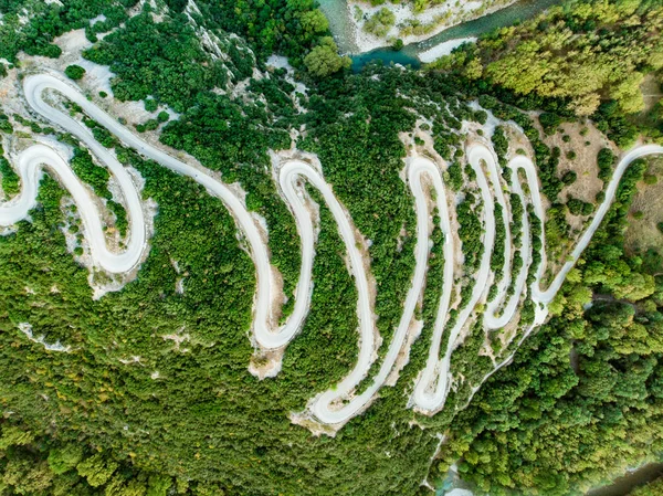 Vista aérea de cima para baixo da estrada estreita serpentina que conduz ao desfiladeiro de Vikos, no norte da Grécia. Uma estrada cheia de reviravoltas e voltas enrolado a montanha na região de Zagori, Grécia . — Fotografia de Stock
