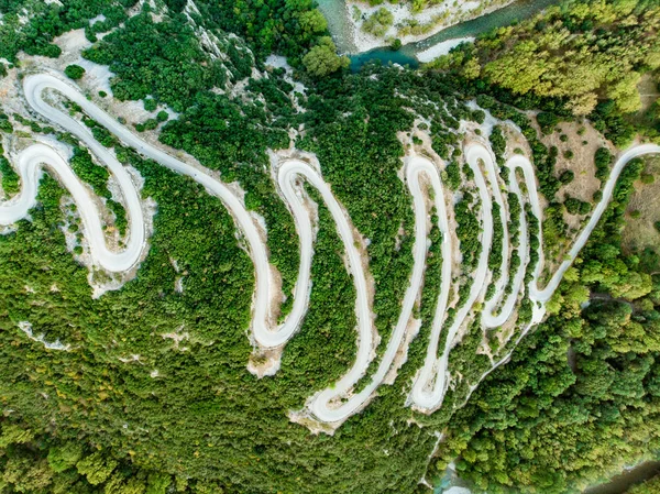 Aerial top down view of serpentine narrow road leading to Vikos Gorge in Northern Greece. A road full of twists and turns winding up the mountain in Zagori region, Greece. — Stock Photo, Image