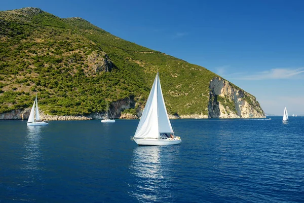 Malerischer Blick auf den Hafen von Nidri mit vorbeifahrenden Booten und Yachten. Küste der Insel Lefkada an einem sonnigen Sommertag. — Stockfoto