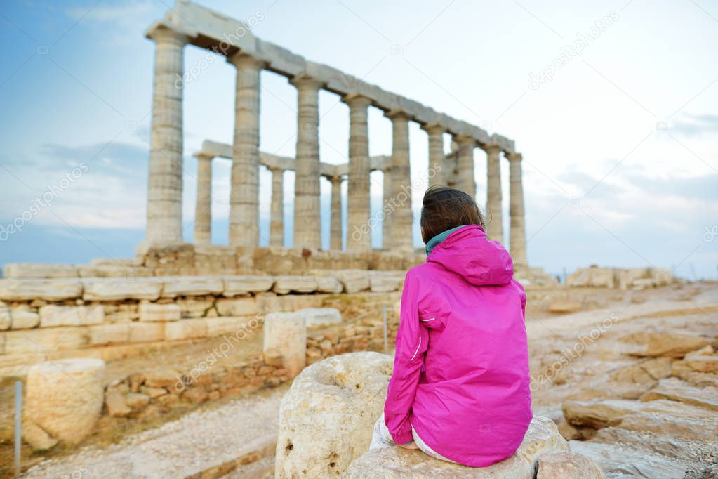 Cute young girl exploring the Ancient Greek temple of Poseidon at Cape Sounion, one of the major monuments of the Golden Age of Athens.