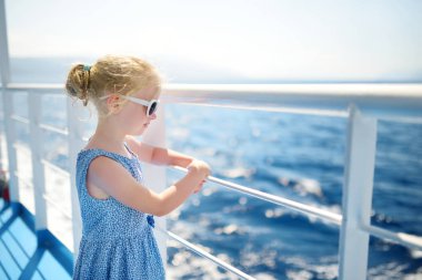 Feribot yolculuğunun tadını çıkaran sevimli genç kız derin mavi denize bakıyor. Yunanistan 'da yaz tatilinde eğlenen bir çocuk. Çocuk tekneye biniyor..