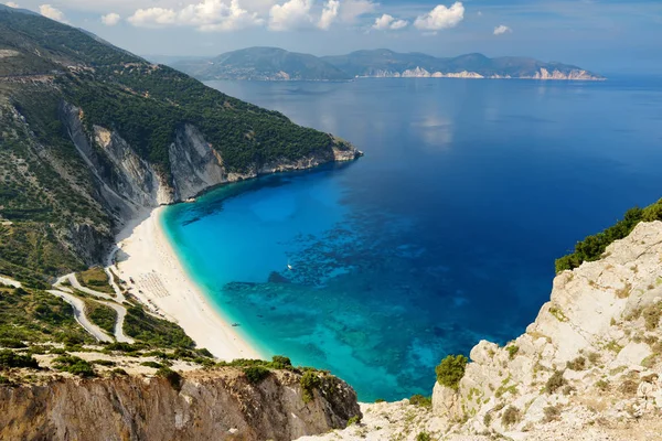 Aerial view of Myrtos beach, the most famous and beautiful beach of Kefalonia, a large coast with turqoise water and white coarse sand, surrounded by steep cliffs. — Stock Photo, Image