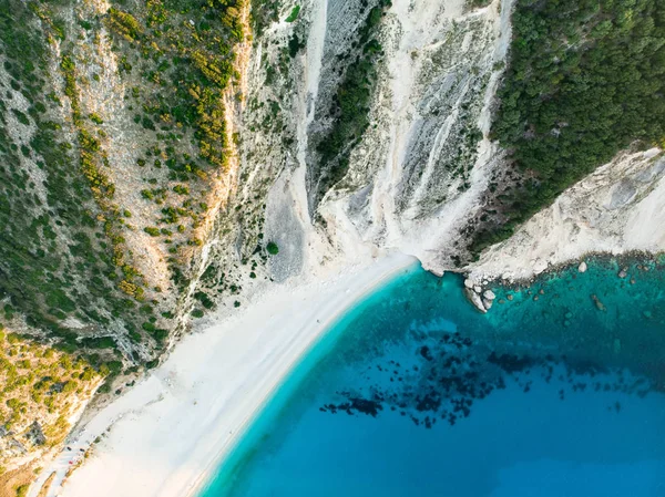 Aerial top down view of Myrtos beach, the most famous and beautiful beach of Kefalonia, a large coast with turqoise water and white coarse sand, surrounded by steep cliffs. — Stock Photo, Image