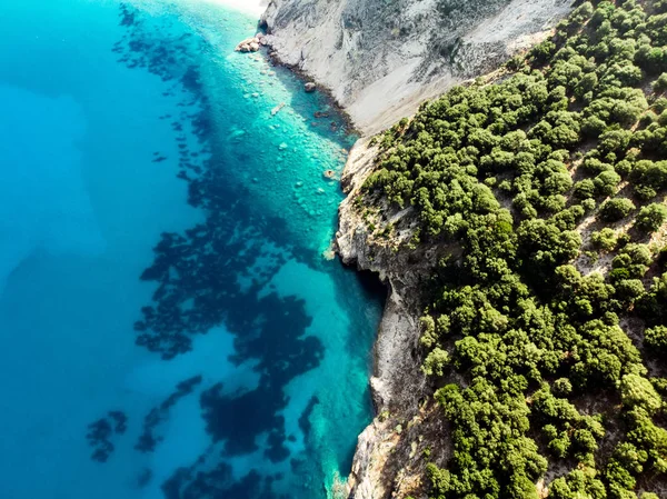 Malerische Luftaufnahme von oben nach unten der malerischen zerklüfteten Küste von kefalonia mit klarem türkisfarbenem Wasser, umgeben von steilen Klippen. — Stockfoto