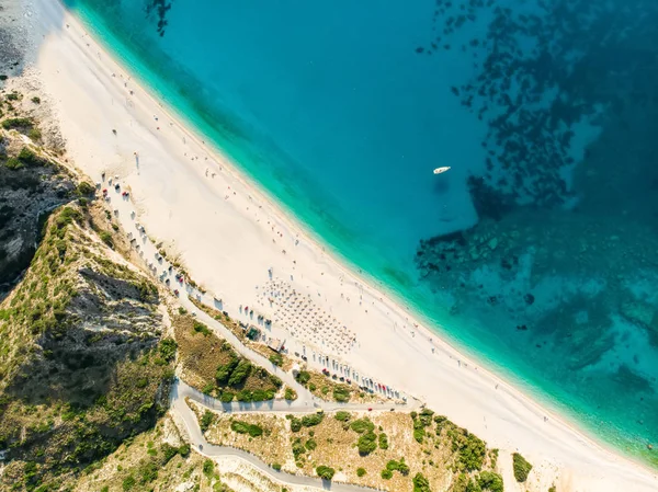 Vista aérea de arriba hacia abajo de la playa de Myrtos, la playa más famosa y hermosa de Cefalonia, una gran costa con agua turquesa y arena gruesa blanca, rodeada de acantilados empinados . — Foto de Stock