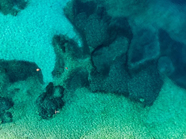 Vista aérea de arriba hacia abajo de Emplisi Beach, pintoresca playa de piedra en una bahía aislada, con aguas cristalinas populares para bucear. Pequeña playa de guijarros cerca de la ciudad de Fiscardo de Cefalonia, Grecia . — Foto de Stock