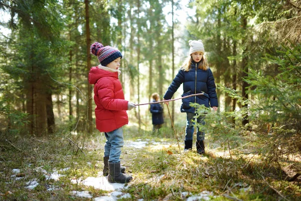 森の中に楽しいかわいい若い姉妹は 美しい冬の日にハイキングします 子供とアクティブなファミリー向けのレジャーです 家族で楽しむ — ストック写真