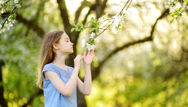 美しい春の日に咲くアップル ツリー庭で愛らしい少女 新鮮なリンゴの木の花をついばんで春かわいい子 — ストック写真