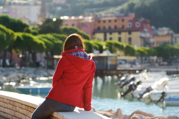Ung kvinnlig turist njuter av utsikten över små båtar och fiskebåtar i marinan i Lerici stad, som ligger i provinsen La Spezia i Ligurien, Italien. — Stockfoto