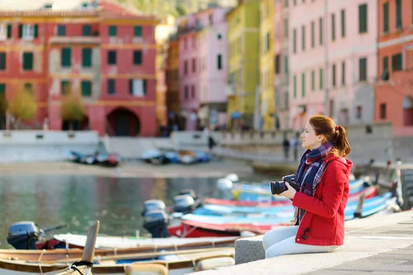 Ung kvinnlig turist njuter av utsikten över Vernazza, en av de fem hundra år gamla byarna i Cinque Terre, som ligger på den oländiga nordvästra kusten av italienska rivieran, Italien. — Stockfoto