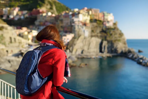 Joven turista disfrutando de la vista de Manarola, uno de los cinco pueblos centenarios de Cinque Terre, situado en la escarpada costa noroeste de la Riviera italiana, Italia . — Foto de Stock