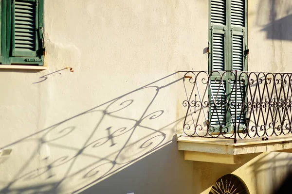 Metal balcony fence casting beautiful shadow on a wall in Riomaggiore, one of the five centuries-old villages of Cinque Terre, Italian Riviera, Liguria, Italy. — Stock Photo, Image