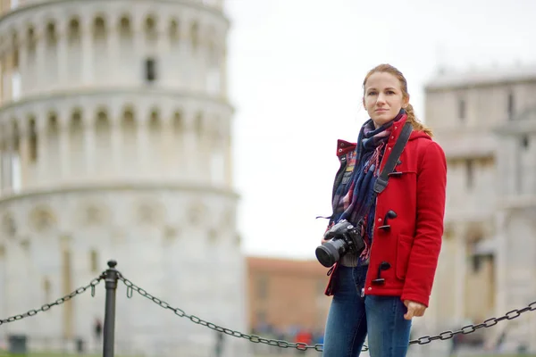 Jonge vrouwelijke toerist maakt foto 's van de beroemde Scheve Toren van Pisa. — Stockfoto