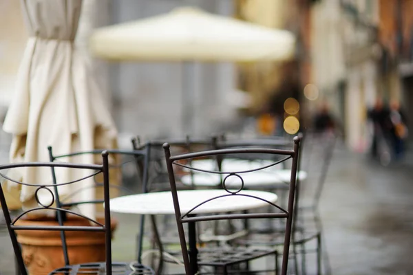 Empty small outdoor restaurant tables on the main square of Lucca, Italy