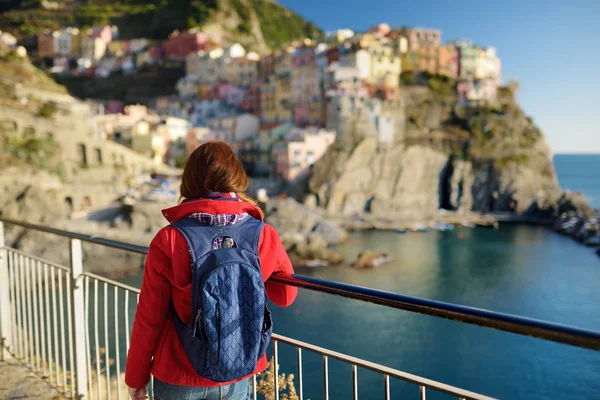 Joven turista disfrutando de la vista de Manarola, uno de los cinco pueblos centenarios de Cinque Terre, situado en la escarpada costa noroeste de la Riviera italiana, Italia . — Foto de Stock