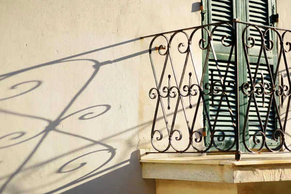 Metalen balkon hek gieten mooie schaduw op een muur in Riomaggiore, een van de vijf eeuwenoude dorpen van Cinque Terre, Italiaanse Rivièra, Ligurië, Italië. — Stockfoto