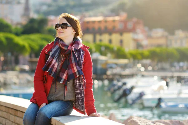 Jonge vrouwelijke toerist die geniet van het uitzicht op kleine jachten en vissersboten in de jachthaven van Lerici stad, gelegen in de provincie La Spezia in Liguria, Italië. — Stockfoto