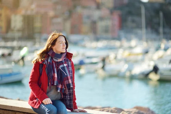 Ung kvinnlig turist njuter av utsikten över små båtar och fiskebåtar i marinan i Lerici stad, som ligger i provinsen La Spezia i Ligurien, Italien. — Stockfoto