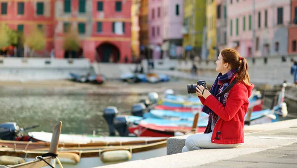 Ung kvinnlig turist njuter av utsikten över Vernazza, en av de fem hundra år gamla byarna i Cinque Terre, som ligger på den oländiga nordvästra kusten av italienska rivieran, Italien. — Stockfoto