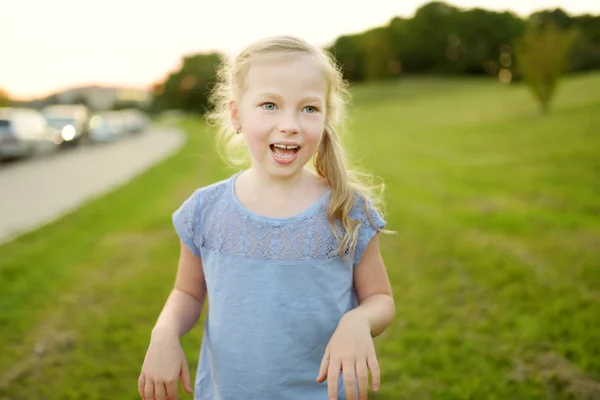 Schattig klein meisje plezier buitenshuis op de zomeravond. Kind de natuur verkent. Zomeractiviteiten voor kinderen. — Stockfoto