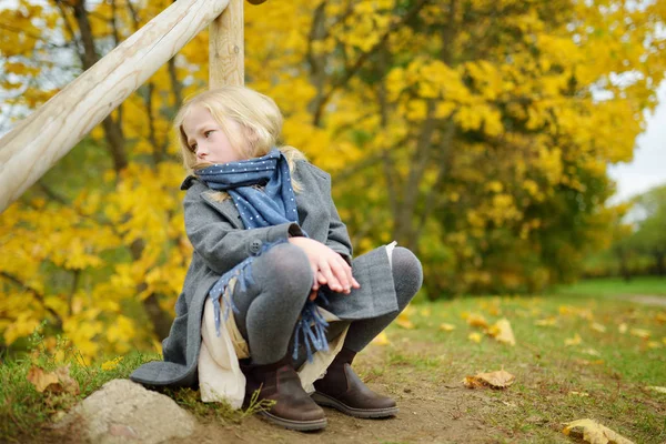 Adorabile ragazza che si diverte nella bella giornata autunnale. Bambino felice che gioca nel parco autunnale. Ragazzo raccolta fogliame caduta gialla . — Foto Stock