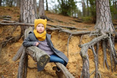 Güzel sonbahar gününde eğlenen sevimli genç kız. Sonbahar parkında oynayan mutlu çocuk. Sonbahar ormanlarını keşfeden çocuk.