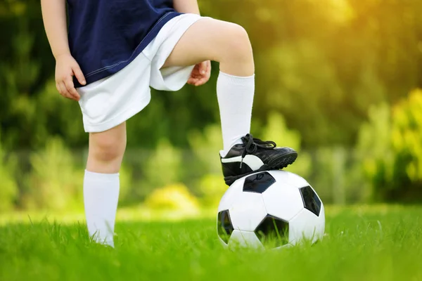 Κοντινό σχέδιο ενός παιδιού που διασκεδάζει παίζοντας ένα παιχνίδι ποδοσφαίρου την ηλιόλουστη μέρα του καλοκαιριού. Αθλητικές δραστηριότητες για παιδιά. — Φωτογραφία Αρχείου