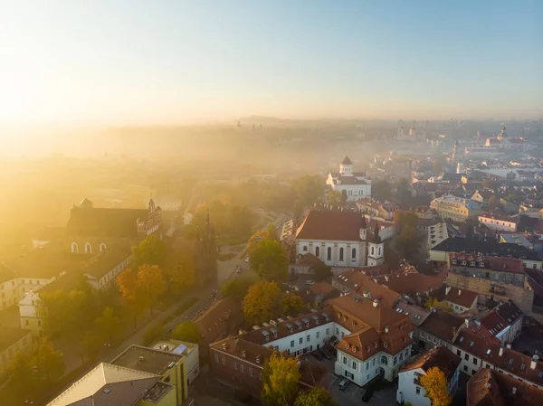 Turuncu ve sarı yaprakları ile sonbaharda güzel sisli Vilnius şehir sahnesi. Havadan sabah ın erken saatlerinde görünümü. — Stok fotoğraf